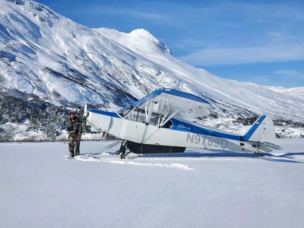 Hunter walking towards a snow-covered mountain peak